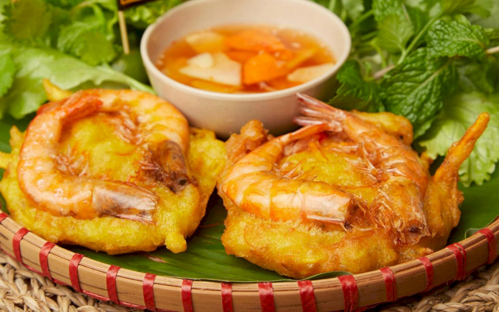 Golden fried banh tom with a crispy sweet potato base and juicy shrimp on top
